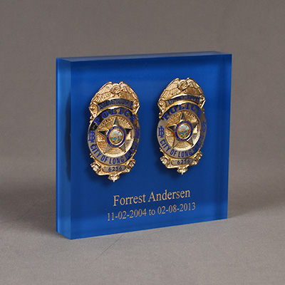 Two retired police badges cast into a Lucite® Embedment with laser engraved and color filled text.